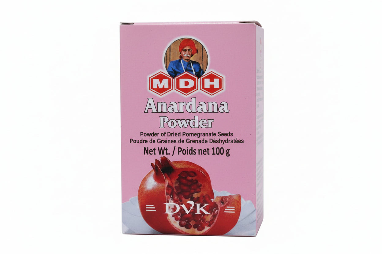 Box of MDH Anardana Powder with a pomegranate on a pink background