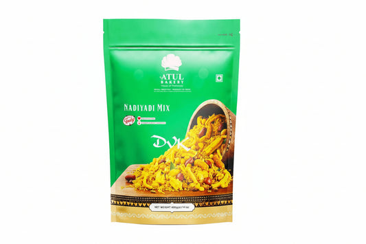 Green package of Atul Bakery Nadiyadi Mix with a wooden bowl of mix on a white background
